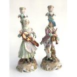 A pair of Meissen candlestick figures, late 19th century in the form of musicians, cross swords to