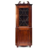 A George III mahogany glazed standing corner cupboard, swan neck's pediment above astragal glazed