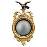 A Regency style giltwood convex mirror, eagle with two balls on chain surmounting the mirror, with