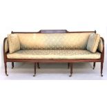 A Regency three seater bergere sofa, with caned seat and upholstered back and sides below a strung