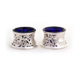 A pair of pierced silver salts with blue liners in the Rococo style, by Sibray, Hall & Co, London