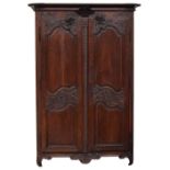 A late 18th century provincial chestnut armoire, fitted with two fielded panel doors, carved with