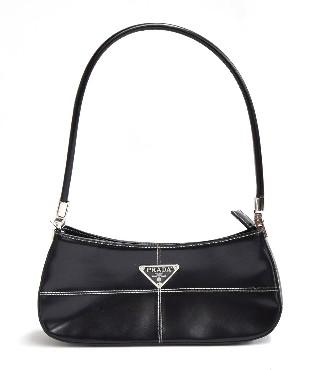 Small firm black leather handbag from Prada with hinged silver hardware holding the handle, very