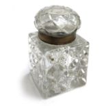 An early 20th century heavy glass inkwell of square section, with brass rim, 9.8cmH