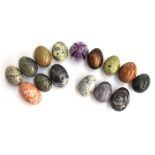 A collection of 14 polished hardstone and mineral specimen eggs, and one blown glass egg