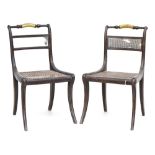 A pair of Regency grained rosewood side chairs, with split cane seats and splats, parcel gilt