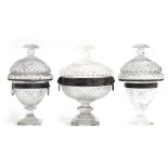 A set of three silvered metal mounted cut glass sweetmeat dishes, each with domed cover, cushion