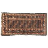 A Persian rug in tones of pink, indigo, and brown, the centre field with narrow tile like pattern,