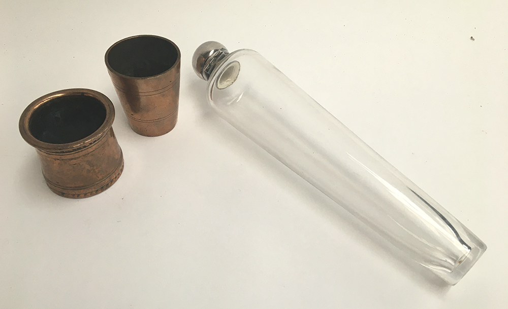 A conical glass Hunting Flask with metal hinged lid 21.5cm high together with a copper stirrup