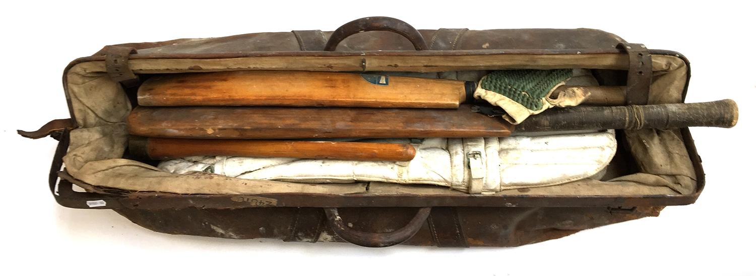 A vintage leather cricket bag containing a pair of pads, gloves, and cricket bat, The Jim Parks