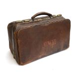 A leather Gladstone bag with brass fittings and fitted interior, monogrammed CWH