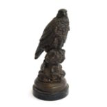 A bronze sculpture of a seated peregrine falcon, raised on a plinth, 30cmH
