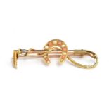 A yellow metal brooch in the form of a horseshoe and riding crop set with seed pearls, 5.7g,