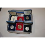 Six various coins contained in Royal Mint boxes