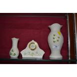 A Belleek mantel clock and two Belleek vases