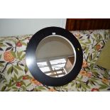 A circular framed wall mirror