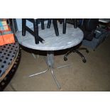 A metal framed garden table with marble effect top