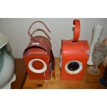 A pair of red painted metal road lanterns