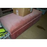 A pink upholstered ottoman