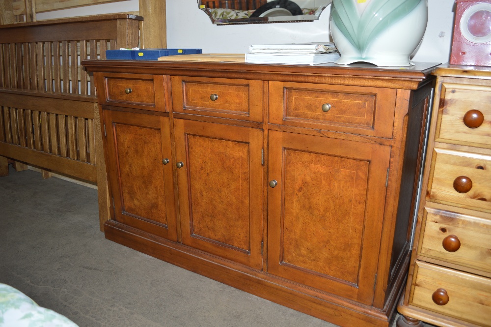 A walnut and mahogany effect three drawer sidebo