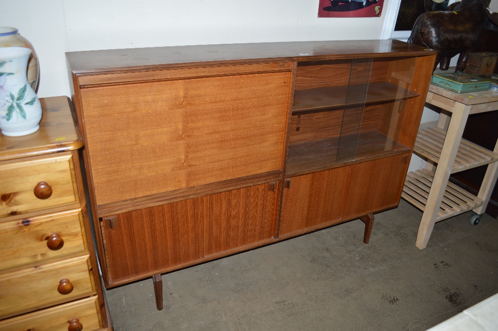 A teak bookcase with sliding glass doors