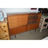 A teak bookcase with sliding glass doors