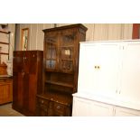 An oak and leaded glazed cabinet raised on cupboar