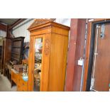 An Edwardian satin wood single door wardrobe