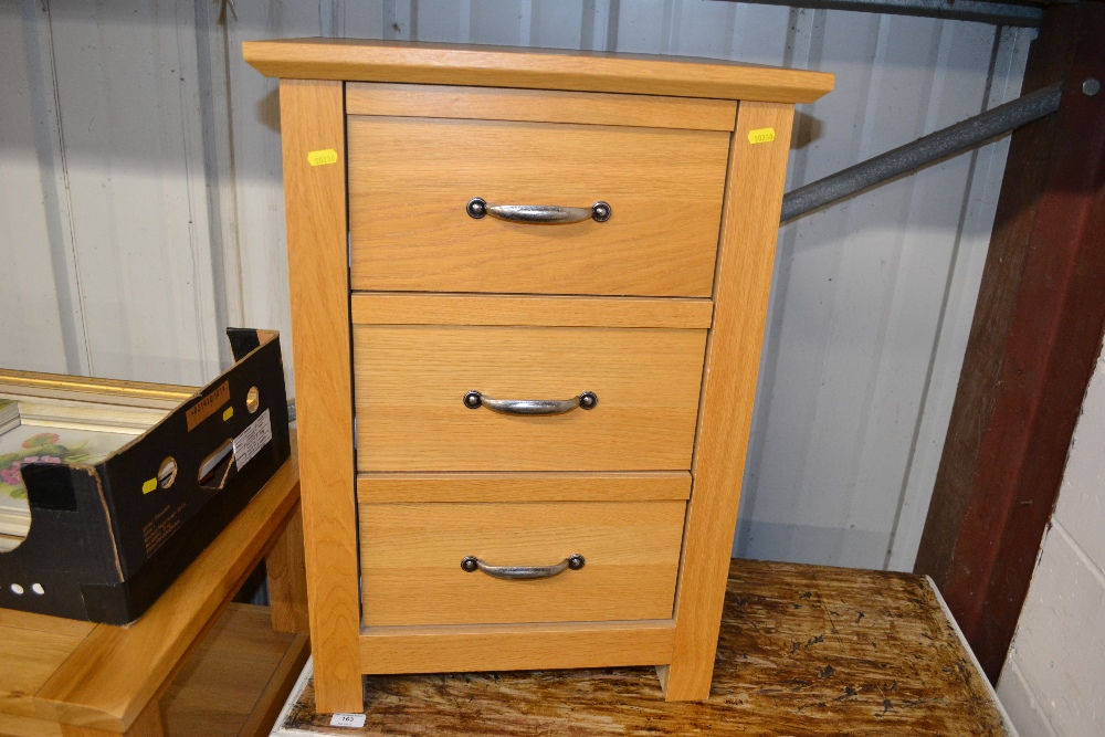 A light oak veneered three drawer bedsdie chest