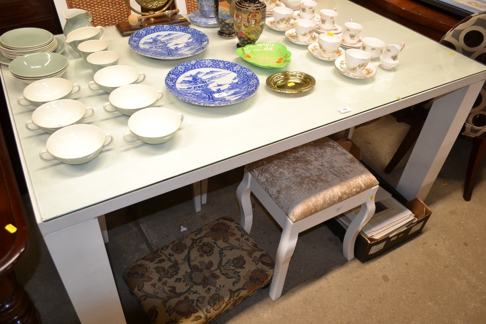 A white painted glass topped dining table with a s