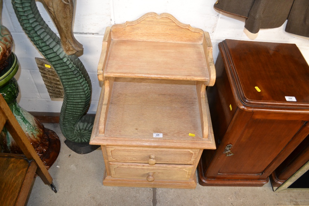 A limed oak bedside table fitted two drawers