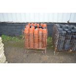 A metal cage and contents of plastic plant pots