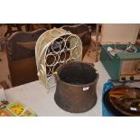 A copper cauldron and a wine rack