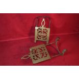 Two ornate brass fire trivets