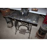 A marble topped garden table with ornate treadle s