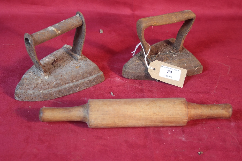 Two old flat irons and a wooden rolling pin