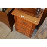 A teak three drawer bedside chest