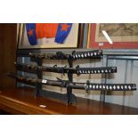 A set of three Japanese swords on stand