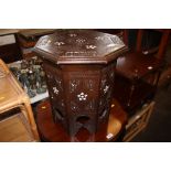 An Eastern carved table with mother of pearl inlay