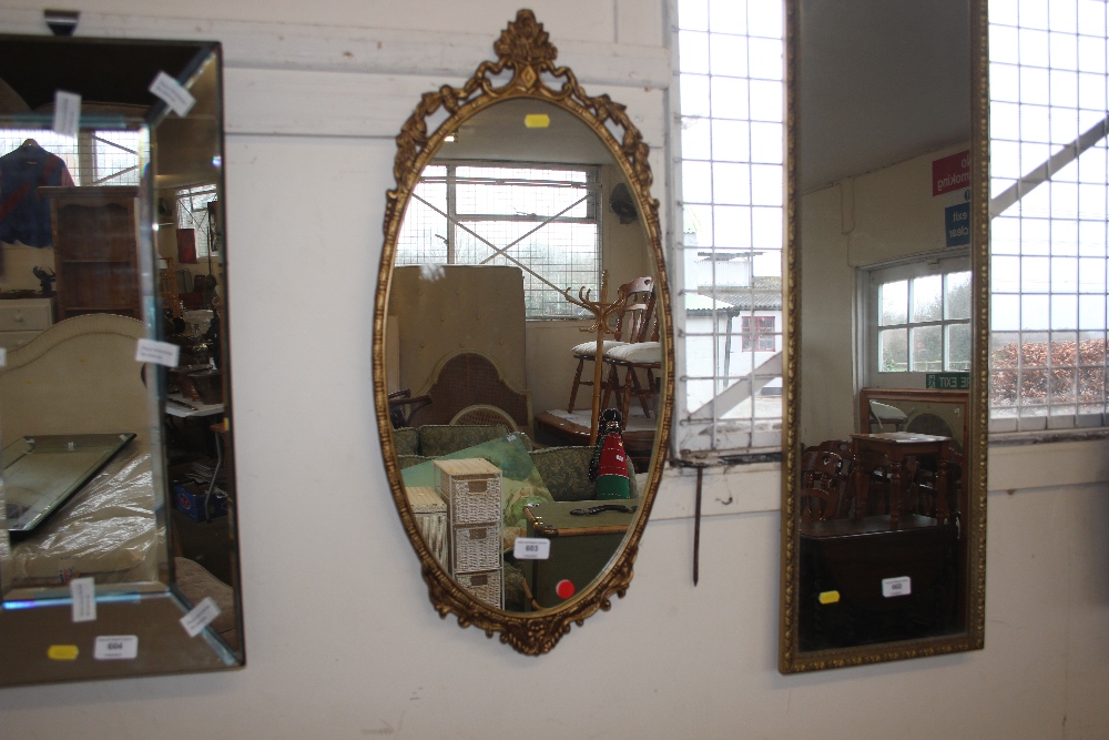 A gilt frame oval mirror with floral darling decor