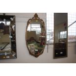 A gilt frame oval mirror with floral darling decor