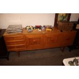 A teak veneered side board fitted three drawers