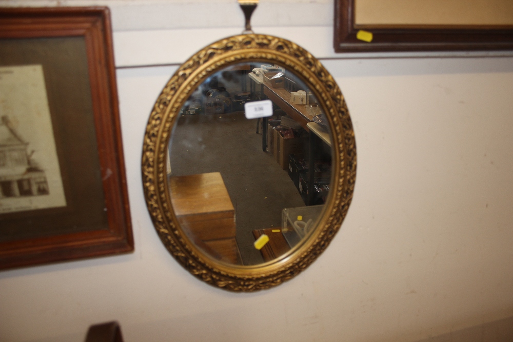 A small gilt oval mirror