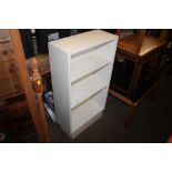 A white painted open fronted bookcase