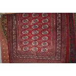 An approx 6'2" x 4'1" red patterned Turkish rug