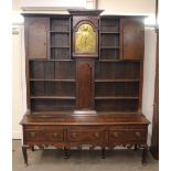 An unusual Georgian oak clock dresser, having shelved and boarded back, three drawers below,