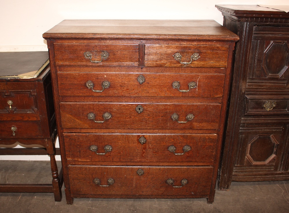 An 18th Century oak chest, fitted two short and four long graduated drawers, raised on bracket feet,