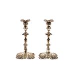 A pair of George II cast silver candlesticks, having floral and shell decoration, with detachable
