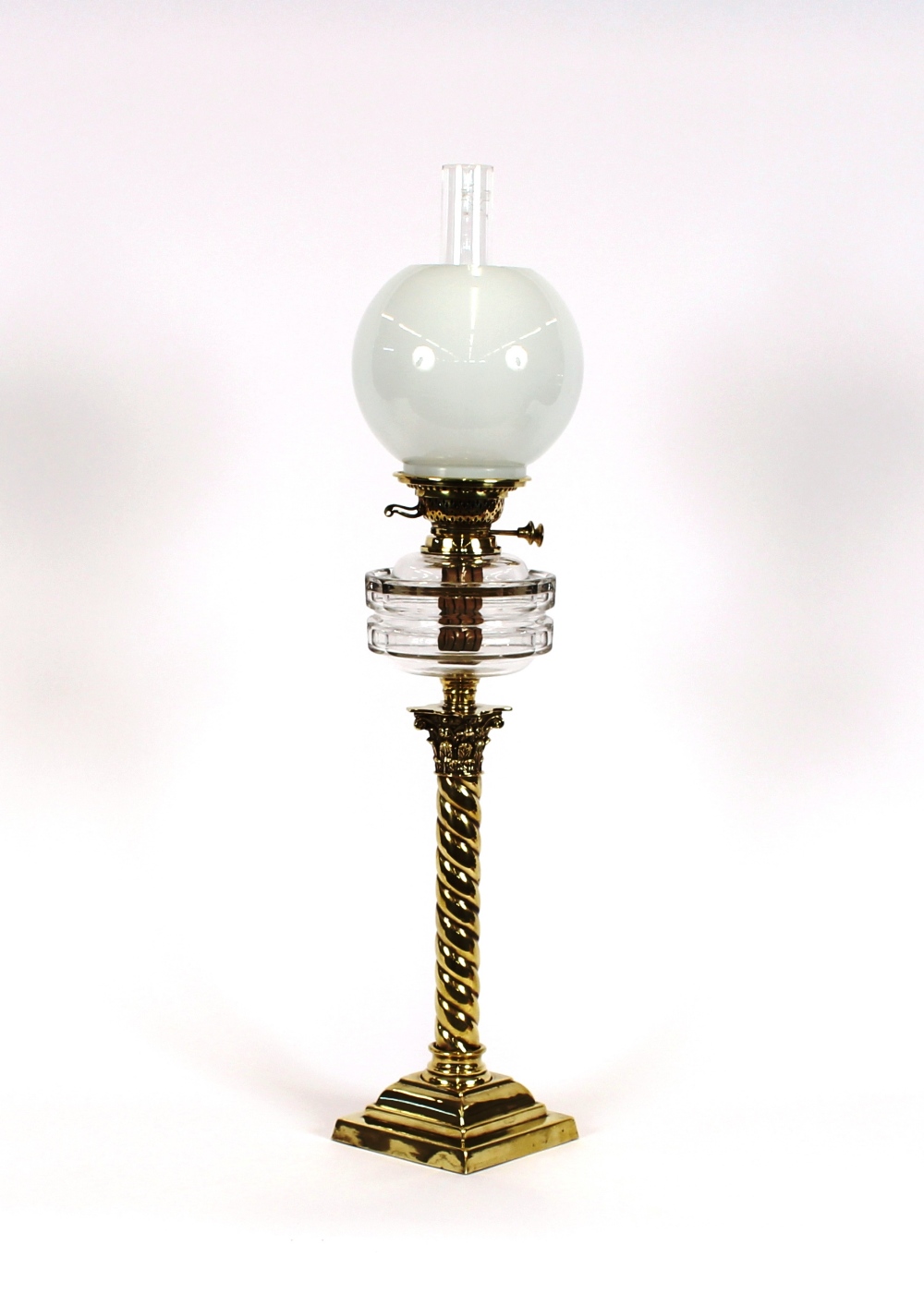 A Victorian brass column oil lamp, having clear glass reservoir and opaque shade, 80cm high