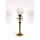 A Victorian brass column oil lamp, having clear glass reservoir and opaque shade, 80cm high